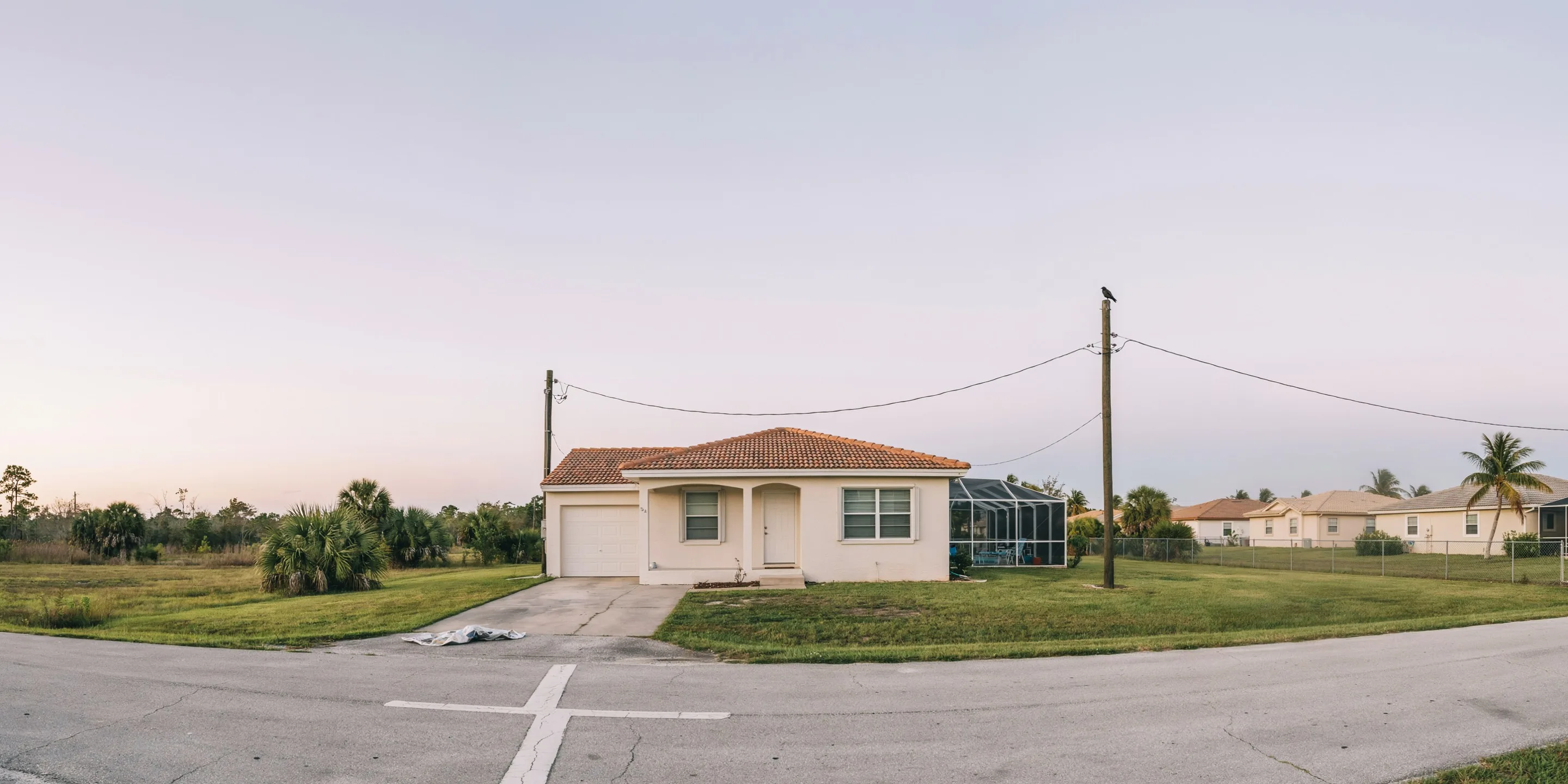 Ranch home with pool cage at dusk in Golden Beach, Venice, FL